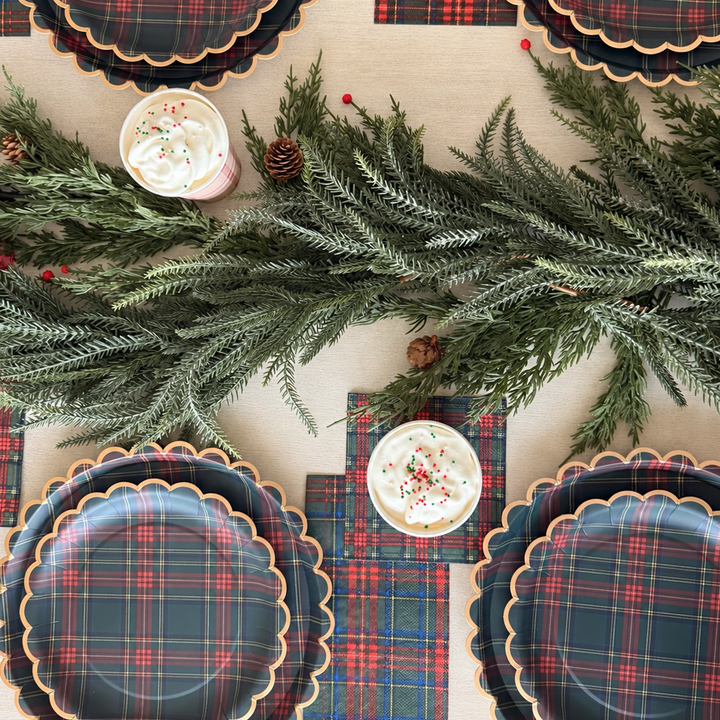 Overhead Christmas tablescape with Heritage Tartan plaid plates, napkins, hot cocoa and evergreen garland